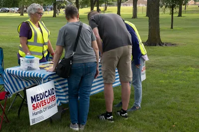 Volunteers staff an information table at the Good Trouble rally in Brookings, South Dakota.